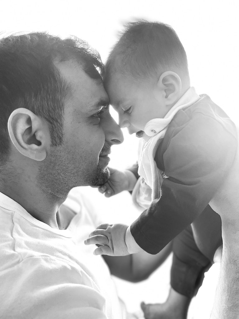 A man and a baby meet forehead to forehead