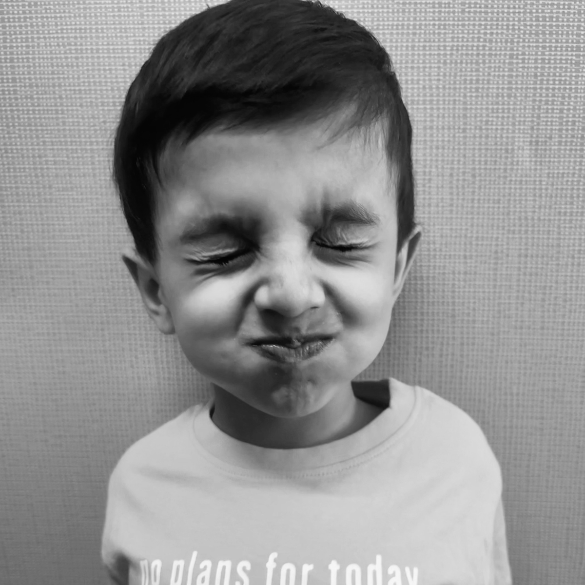 A young child with eyes closed and cheeks puffed out, attempting to hold their breath for as long as possible during imaging.
