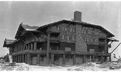 A large stone and wood building with balconies and a chimney, surrounded by snow.
