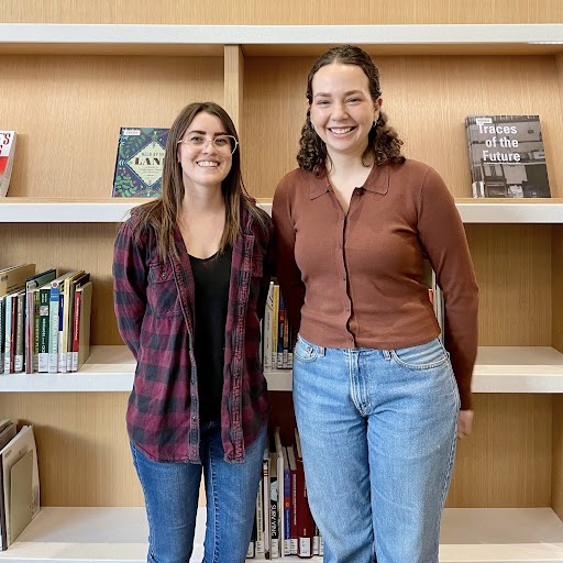 Two Indigenous Interns in front of a bookshelf