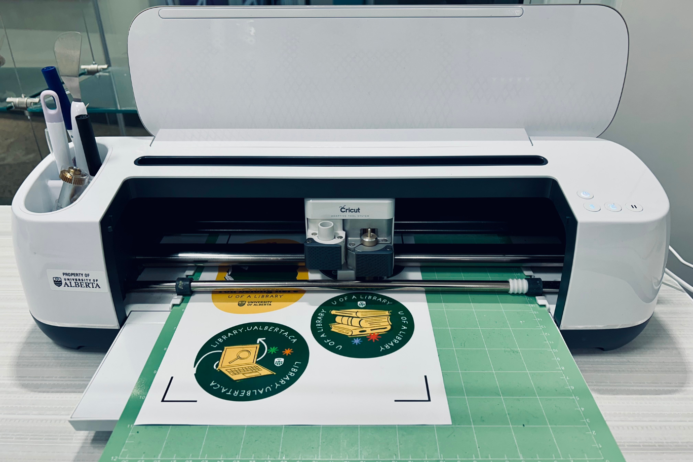 A Cricut Maker machine cuts out sticker designs.