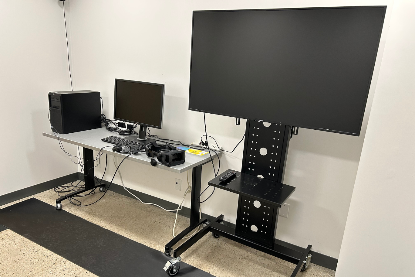 The DSC's virtual reality studio with computer, screens, and VR headset and controllers.